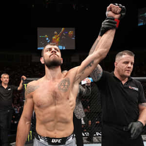 UFC拳手在裁判舉起他的手臂時，高舉拳頭慶祝勝利。 — 1:1 壁紙