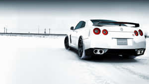 白色日產GT-R跑車在冬季雪路上行駛。