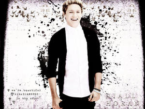 Niall Horan 穿著白色襯衫和黑色開襟衫，在藝術潑濺背景中微笑。