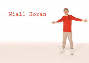 Niall Horan 身穿紅色毛衣在工作室中微笑並張開雙臂