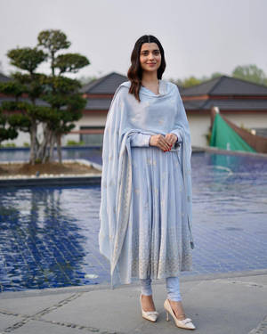 身穿藍色傳統服飾的女性站在游泳池旁