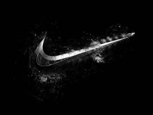 在黑色背景上由爆炸的白色粉末形成的Nike swoosh標誌