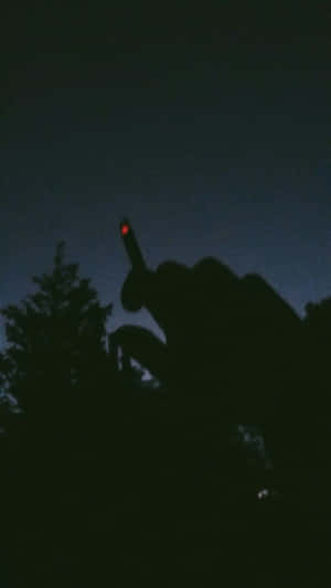 一隻手向上指，帶有紅光，映襯著黑暗的天空。