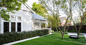 白色房屋，帶門廊和花園，在晴朗的日光下