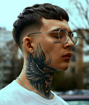 有天使翼紋身和戴眼鏡的年輕男子在日落時戶外站立。