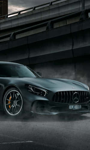 啞灰色梅賽德斯-AMG GT跑車在混凝土天橋下飄移。