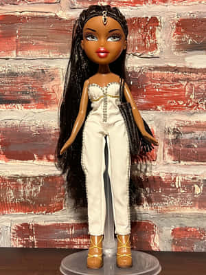 Bratz 公仔穿著白色連身褲和棕色靴子，背景為紅磚牆。