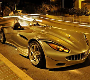 金色跑車夜間停泊在濕滑街道上，帶有光軌。 — 金色美學 GIF 壁紙