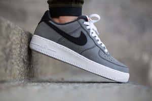 灰色Nike Air Force 1運動鞋配白色鞋帶在石階上。