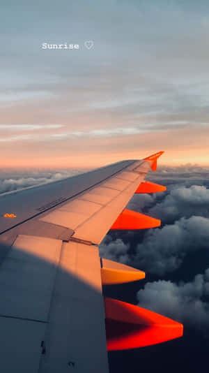 日出時的飛機機翼，雲層上方有橙色光芒