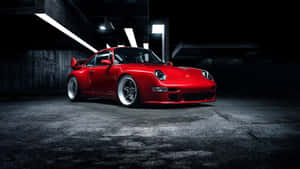 紅色保時捷911 Turbo停在燈光昏暗的地下停車場，帶有戲劇性照明。