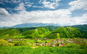 綠色山谷中的村莊，有山脈和藍天
