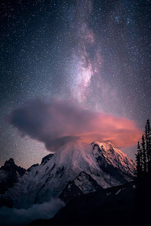 星空下的雪山，銀河和粉紅色的雲。