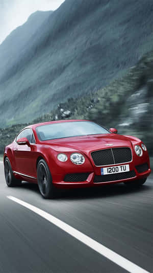 紅色賓利跑車在日落時分於山路上疾馳