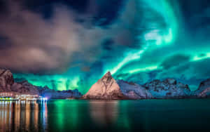 綠色北極光在雪山上和夜晚點亮的峽灣上閃爍。 — 1280x800 壁紙