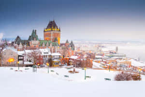 白雪覆蓋的魁北克市，黃昏時分燈火通明的建築物和城堡。