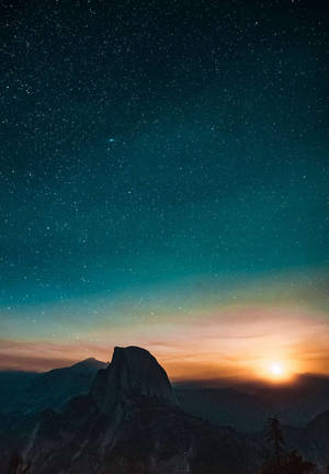 黃昏時分的山頂，星星和發光的太陽在天空中