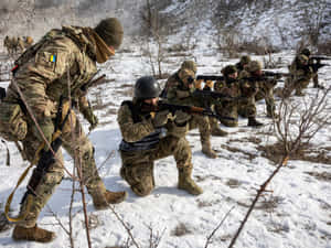 穿著冬季迷彩的士兵持步槍在雪中前進。 — 戰爭 壁紙