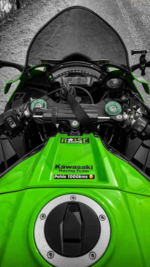 綠色Kawasaki賽車電單車儀表板，帶有1000kms貼紙，位於碎石路上。