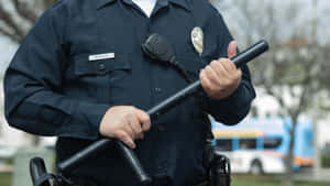 警察在戶外手持警棍，制服上掛著對講機。