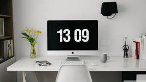 簡約家居辦公室，iMac 顯示日期，周圍環繞書籍和鮮花。