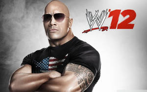 狄維·莊遜在WWE 12宣傳照中雙臂交叉並戴太陽眼鏡。