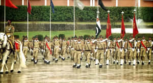 在雨中軍事閱兵中，身穿制服的士兵與旗幟和一名騎兵軍官一起列隊行進。