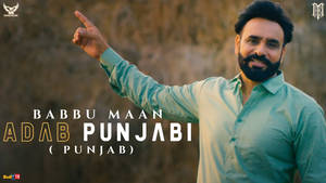 身穿青綠色襯衫的男子指向文字 Babbu Maan Adab Punjabi