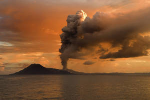 火山爆發，火山灰雲，橙色日落，海洋上方