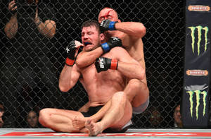 兩名男性MMA拳手在八角籠內進行血腥的纏鬥比賽。 — 拳擊 壁紙