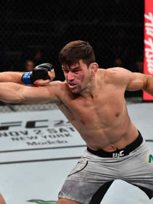 一名男性MMA拳手在比賽中於UFC八角籠內揮拳。 — 冠軍 壁紙