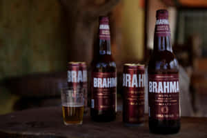 木桌上的 Brahma 啤酒瓶、罐和玻璃杯