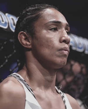 一位堅定的女MMA戰士在籠內穿著白色背心。