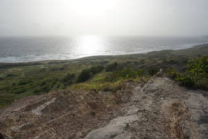 在霧氣瀰漫的日落光線下，從懸崖俯瞰海洋和海灘的景色。 — 牙買加海灘 壁紙