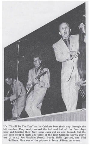 Buddy Holly 與樂隊在黑白照片中現場舞台表演。
