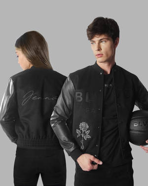 穿著黑色 bomber 外套的男子和女子拿著籃球。