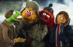 四個Muppet角色裹著冬季裝備站在雪中。