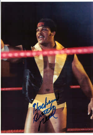 摔角手 Blackjack Mulligan 在擂台上穿著金色和黑色服裝，簽名清晰可見。 — 摔角 GIF 壁紙