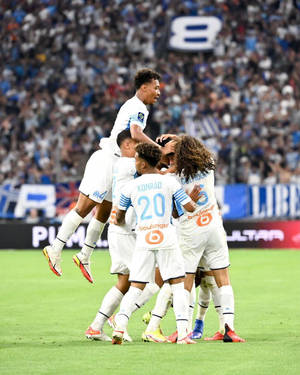 足球運動員在座無虛席的體育場內慶祝入球。 — 4:5 壁紙