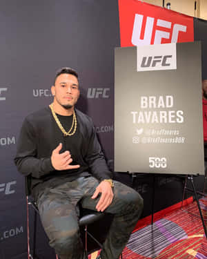 Brad Tavares 坐在 UFC 記者會上，身穿黑色襯衫和迷彩褲。 — 火影忍者海報 壁紙
