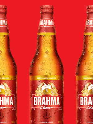 三瓶冰凍的Brahma啤酒瓶，紅色背景上有冷凝水珠。
