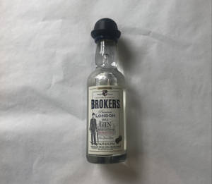 一小瓶 Broker's 氈酒放在白色布料背景上。