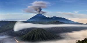 黎明時分，煙霧從霧氣瀰漫的山谷上空升起的火山噴發。