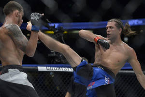 兩名男性拳手在MMA比賽中於八角籠內交換高踢和阻擋。