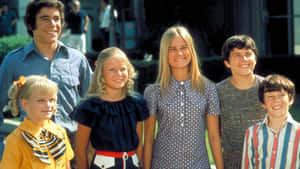 一個幸福的六口之家穿著1970年代服裝在晴朗的日子裡戶外微笑。