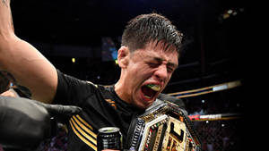 MMA拳手手持冠軍腰帶和維他命水罐慶祝勝利。