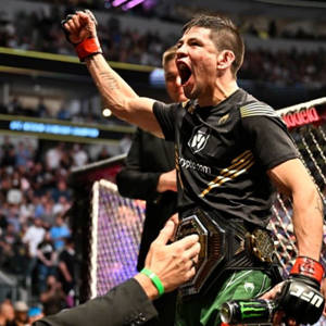 MMA拳手在八角籠內手持冠軍腰帶慶祝勝利。