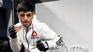 MMA拳手身穿白色連帽衫和黑色手套在更衣室擺姿勢