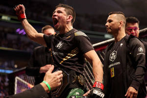 MMA拳手在競技場中手持冠軍腰帶慶祝勝利。