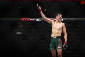 UFC拳手在八角籠內舉手慶祝勝利。